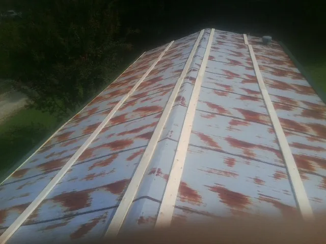 Rusted metal roof panels with new wood purlins before replacement — Storm Damage Roof Repair in Coeburn by Roofing Brothers