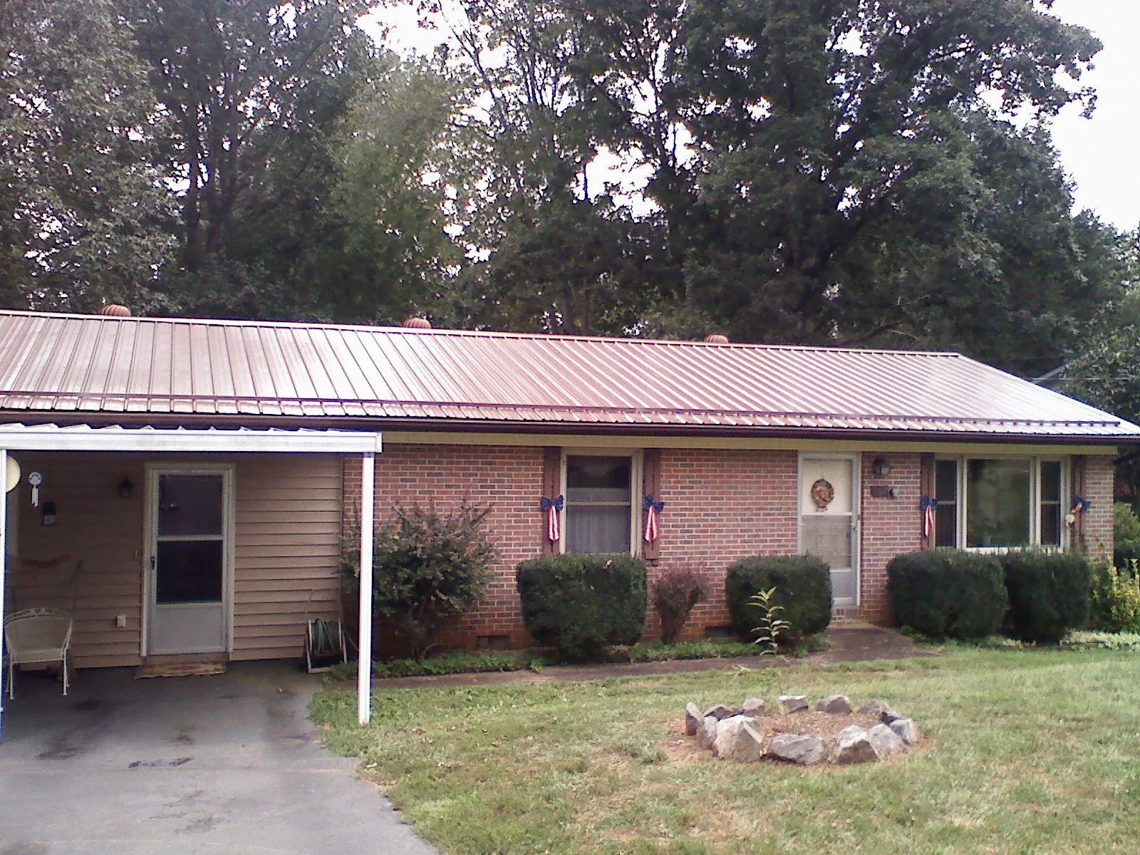 Bronze metal roof and carport on a brick ranch home — Roof Repair work by our crew in Coeburn
